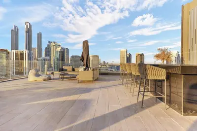 a rooftop deck with chairs and a view of a city at Waves - Stylish Studio Near Downtown Dubai in Dubai
