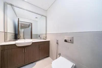 a bathroom with a sink and a toilet and a mirror at Prestige Jumeirah 4BR Villa with Rooftop and Private Garden in Dubai