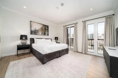 a white bedroom with a bed and a television at Prestige Jumeirah 4BR Villa with Rooftop and Private Garden in Dubai