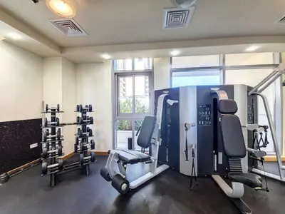 a gym with several tread machines in a room at Iris Blue - Colourful One Bedroom in The Marina in Dubai