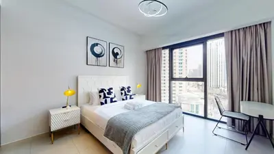 a white bedroom with a bed and a large window at Vacationer l Vibrant 2 Bedroom l Pool with Burj Khalifa View in Dubai
