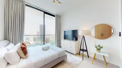 a bedroom with a white bed and a large window at Binghatti Tulip - High Rise Upgraded Studio in JVC in Dubai