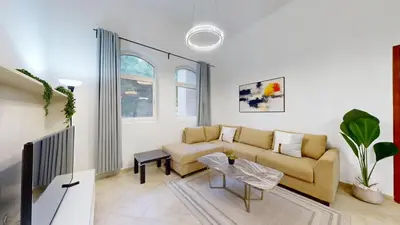 a living room with a couch and a table at Sherlock House 2 - Peaceful One Bed in Motor City in Dubai