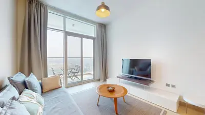 a living room with a couch and a tv at Studio One - Sleek One Bedroom with City View in Dubai