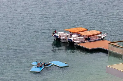 two boats are docked at a dock in the water at Palm Jumeirah Luxury Apt Direct Beach Access & Views in Dubai