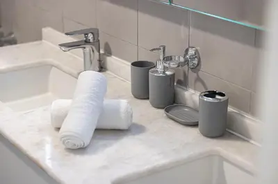 a bathroom counter with a sink and toiletries at Palm Jumeirah Luxury Apt Direct Beach Access & Views in Dubai