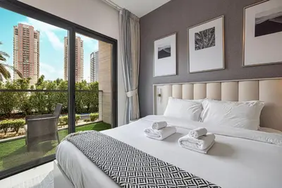 a bedroom with a large bed and a large window at Lush 1BR Oasis in JVC With Gym & 5min to Circle Mall in Dubai