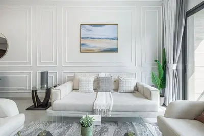 a white living room with a couch and a table at Lush 1BR Oasis in JVC With Gym & 5min to Circle Mall in Dubai