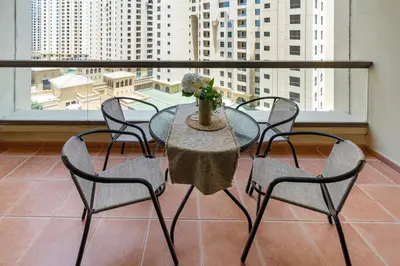 a table and chairs in a room with a window at Rimal 3, JBR - Studio Apartment - Allsopp & Allsopp in Dubai