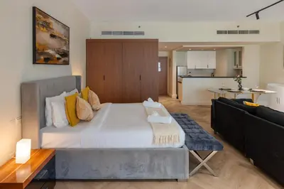 a bedroom with a large bed and a living room at Rimal 3, JBR - Studio Apartment - Allsopp & Allsopp in Dubai