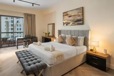 a bedroom with a large bed and a living room at Rimal 3, JBR - Studio Apartment - Allsopp & Allsopp in Dubai