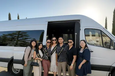 a group of people standing in front of a van at Royal Rider Bus rental Dubai in Dubai