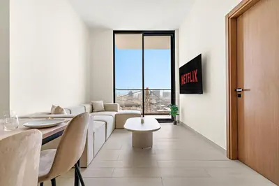 a living room with a couch and a table at Vayk - Modern 1BR Apartment in JVC in Dubai