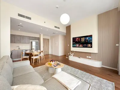 a living room with a couch and a table at Dubai Hills 2BR Full Park View and Designer Style in Dubai