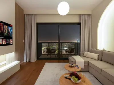 a living room with a couch and a table at Dubai Hills 2BR Full Park View and Designer Style in Dubai