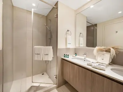 a bathroom with a shower and a sink and a mirror at Dubai Hills 2BR Full Park View and Designer Style in Dubai