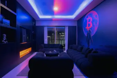 a living room with a couch and a b sign on the wall at Bitcoin Moonrise 2BR - Grande Burj Views in Dubai
