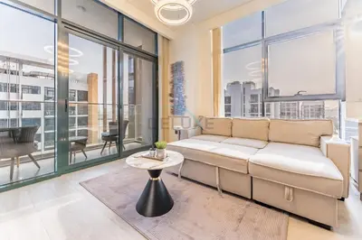 a living room with a couch and a table at Peaceful 1BR with Community View, Quick Downtown and Golf Club Access, Azizi Riviera 34, Al Merkadh by Deluxe Holiday Homes in Dubai