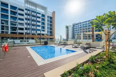 a swimming pool in the middle of a building at Peaceful 1BR with Community View, Quick Downtown and Golf Club Access, Azizi Riviera 34, Al Merkadh by Deluxe Holiday Homes in Dubai
