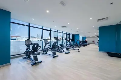 a gym with rows of treadmills and exercise bikes at Peaceful 1BR with Community View, Quick Downtown and Golf Club Access, Azizi Riviera 34, Al Merkadh by Deluxe Holiday Homes in Dubai
