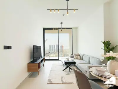 a living room with a couch and a table at Stylish 1BR Retreat in Binghatti Amber l Balcony in Dubai