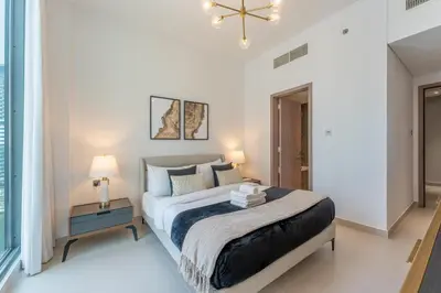 a bedroom with a large bed and a chandelier at Unique & Stunning Marina Views LIV Residence 2BR in Dubai