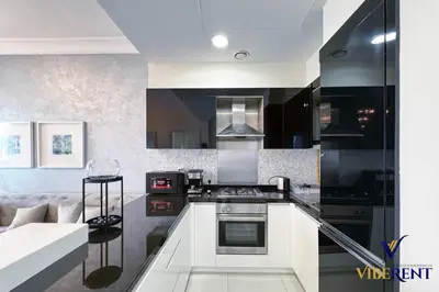 a kitchen with black and white appliances and a couch at Hotel Apartment next to Dubai Mall,Views & Vibes in Dubai