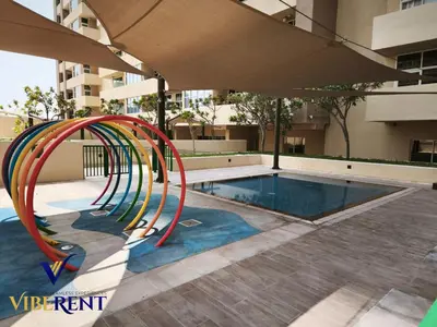 a slide in a pool next to a building at Damac 1BHK, Terrance Pool, 20 Min to Downtown in Dubai
