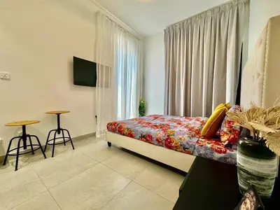 a bedroom with a bed and a window and a table at Stunning studio with balcony close to metro in Dubai