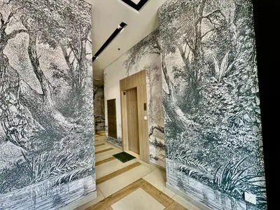 a hallway with a mural of trees on the wall at Stunning studio with balcony close to metro in Dubai
