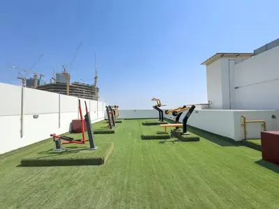 a gym on the roof of a building with green grass at Vogue Arjan Opalz by Danube near Science Park, Studio Apartment with Balcony and Vibrant Community View, Access to all Amenities in Dubai