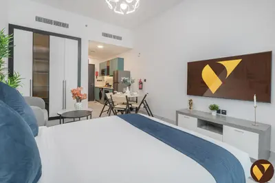 a bedroom with a bed and a living room at Vogue Arjan Opalz by Danube near Science Park, Studio Apartment with Balcony and Vibrant Community View, Access to all Amenities in Dubai