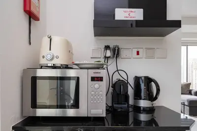 a microwave sitting on top of a counter in a kitchen at Waterfront Luxury 2 Bed in Marina Mall Hotel in Dubai