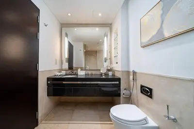 a bathroom with a toilet and a sink and a mirror at Waterfront Luxury 2 Bed in Marina Mall Hotel in Dubai