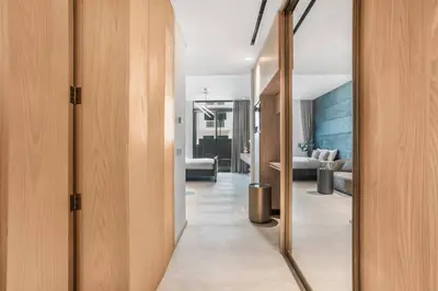 a hallway leading to a living room with a mirror at Brand New Luxury Studio in JVC in Dubai