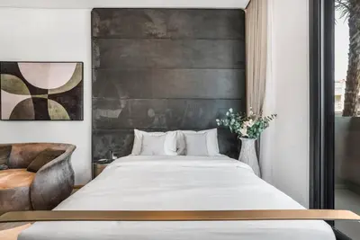a bedroom with a large bed and a chair at Brand New Luxury Studio in JVC in Dubai