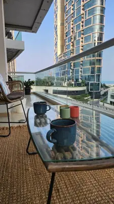 a glass table with pots and pans on a balcony at Sea Breeze Luxury 2BR, Dubai Marina, Big Terrace, Near Beach, Pool access, by Stay Vista! for up to 6 Guests in Dubai