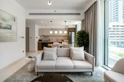 a living room with a couch and a kitchen at Beach Isle 1 Emaar Beachfront - Mint Stay in Dubai
