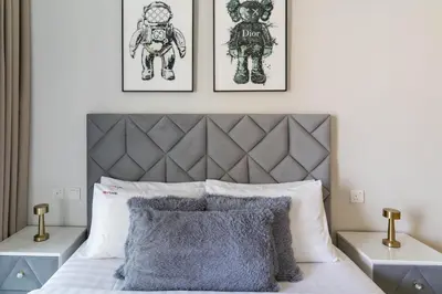 a bedroom with a bed with two pictures on the wall at Modern 1BR in Aykon City - Near Burj Khalifa & Canal in Dubai