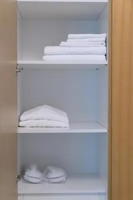a closet with white towels sitting on shelves at Business Bay 1br with High-Floor Views in Dubai