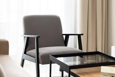a chair in a living room with a glass coffee table at Business Bay 1br with High-Floor Views in Dubai