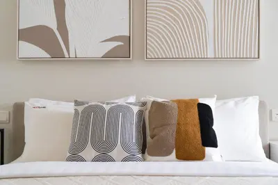 a bedroom with a bed with pillows and paintings at Business Bay 1br with High-Floor Views in Dubai