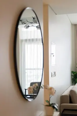 a mirror hanging on a wall in a living room at Business Bay 1br with High-Floor Views in Dubai