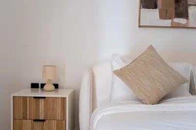 a bedroom with a bed and a night stand with a lamp at Luxury 2BR with Canal & Pool View Nr Downtown in Dubai