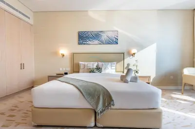 a bedroom with a large white bed in a room at Steps from Nakheel Mall and Monorail Station, Near Beach Clubs ,15 Mins to Downtown and Marina, The Palm Tower, Palm Jumeirah by Deluxe Holiday Homes in Dubai