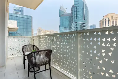 a balcony with two chairs and a table at Steps from Marina Beach, AquaFun & The Walk, Mins to Bluewaters Island and Ain Dubai - La Vie, Jumeirah Beach Residence by Deluxe Holiday Homes in Dubai