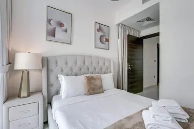 a white bedroom with a large bed and a lamp at PVH - Chic 3BR Villa with Backyard - Albizia in Dubai