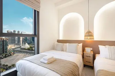 a bedroom with two beds and a large window at Mahogany 17 - 2BR 10PAX - On the Boulevard Sea View in Dubai