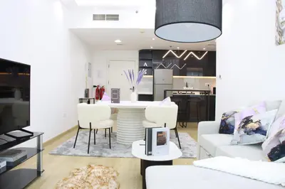 a living room with a white couch and a table at Dubai Marina 1BR with Balcony, Near Metro, Walk to JBR beach & Marina Promenade in Dubai