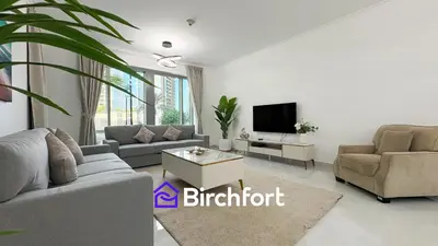 a living room with a couch and a tv at Birchfort- Downtown Living with Burj Khalifa View in Dubai